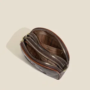 Brown leather boston bag with triple zipper compartments and golden metal hardware