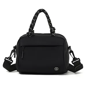 Versatile black nylon crossbody bag with woven handles and wide adjustable strap