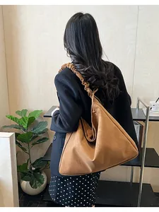 Detail of camel suede tote bag with stylish wide ruched strap for commuting
