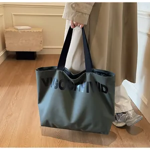 Close-up of olive green tote bag featuring black VIGOURVIVID text and fabric handles