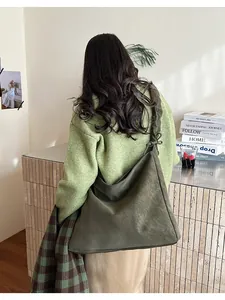 Detail of olive green suede tote bag showing side drawstring and soft material texture