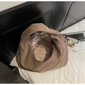 Détail intérieur d'un sac fourre-tout en velours côtelé marron avec doublure et poche