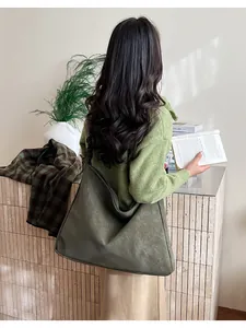Green faux suede tote bag shown on model highlighting its soft texture and large capacity