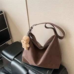 Dark brown retro PU leather tote bag with a plush bear charm for a stylish commute