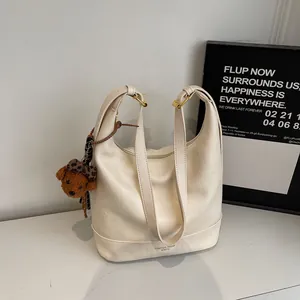 Minimalist off-white oversized hobo shoulder bag with a cute teddy bear charm
