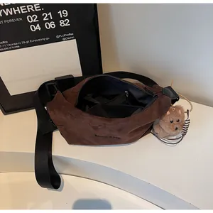 Détail de l'intérieur d'un sac bandoulière en daim marron avec sangle et peluche