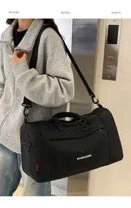 Detail of black large capacity oxford bag showing durable handles and adjustable strap