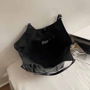 Quilted black tote bag for women showing a large interior space and magnetic closure