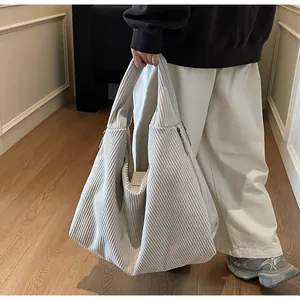 Vue détaillée du sac cabas en velours côtelé blanc cassé avec texture et zip argenté
