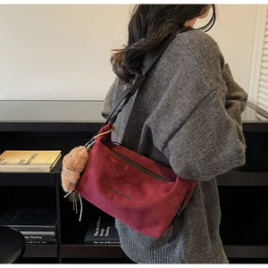 Détail du sac bandoulière bordeaux en daim avec pendentif ours et chaîne en perles