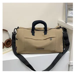 Close-up of khaki Oxford cloth gym bag with black handles and DANDIXIONG logo