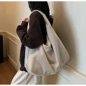 Gros plan du sac fourre-tout en velours côtelé crème montrant la texture du tissu