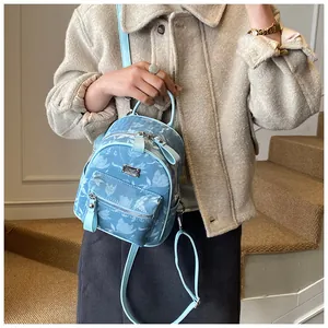 Detail of light blue floral mini backpack with silver logo and adjustable straps