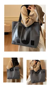 Detailed view of large grey canvas tote bag with black letters for daily office commute