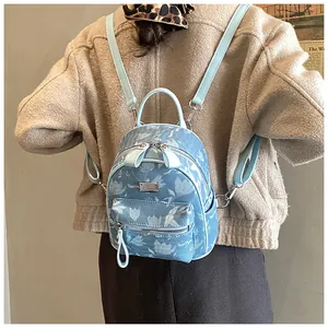 Detail of floral mini backpack featuring high-density fabric and light blue leather straps