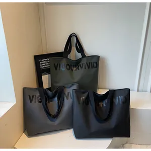 Detailed view of the large capacity tote bags in dark green, grey, and black colors