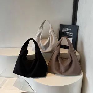 Trois sacs d'épaule en velours côtelé noir beige et marron sur supports d'exposition