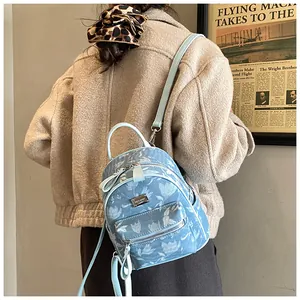 Detailed back view of a mini light blue floral backpack with white tulip patterns