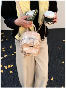 Mini beige backpack with white floral print shown in a cozy autumn outdoor street setting