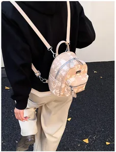 Detailed back view of a mini floral backpack with silver zippers on a model's shoulder