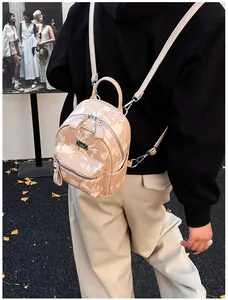 Outdoor shot of a beige floral mini backpack with adjustable straps on a black outfit