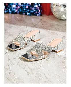 Close-up of silver sequin criss-cross straps on square-toe block heel sandals