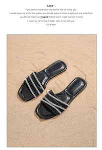 Detail von böhmischen flachen Sandalen mit schwarzen Strassriemen auf weichem Sand