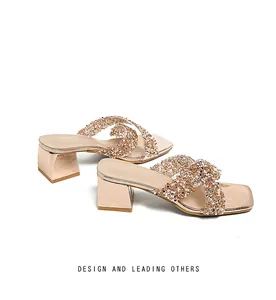 Close-up of champagne gold platform slide sandals with rhinestone straps and metallic heels