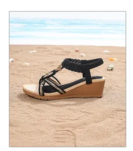 Détail de sandales compensées bohèmes avec brides dorées et semelle imitation bois
