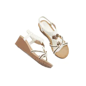 Sandales compensées blanches bohèmes avec brides tressées et détails floraux en métal
