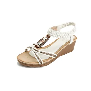 White bohemian wedge sandals with woven leather straps and wood buckle accents