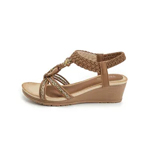 Sandales compensées bohèmes marron avec brides tressées et talon élastique.