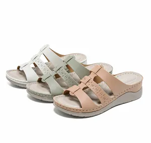 Detailoverzicht van dames sandalen met sleehak en uitgesneden bandjes in wit groen en roze