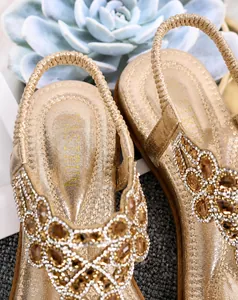 Detail of bohemian gold flat sandals with floral rhinestones and microfiber cushioned sole
