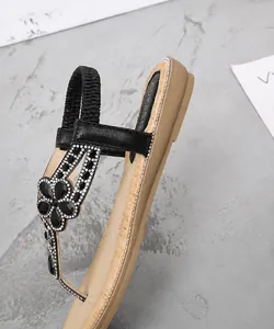 Vue détaillée de sandales plates pour femmes avec talon de 2,5 cm et fleurs en strass noirs