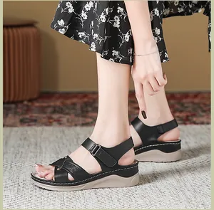 Nahaufnahme schwarzer Plateau-Sandalen mit strukturierten Riemen und weißen Nähten