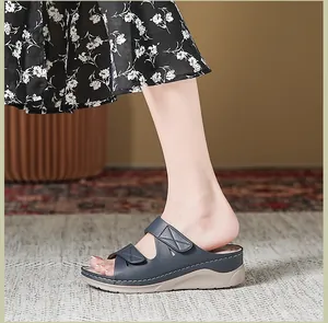 Primer plano de sandalias con cuña azul marino y costuras blancas de alto contraste
