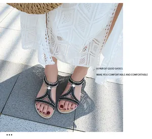 Dettaglio di sandali bassi bohemian con cinturino a T e decorazioni in strass scintillanti