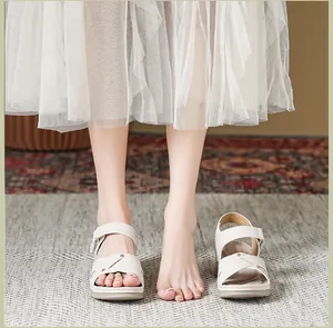 Detailansicht der cremefarbenen Plateausandalen mit Metallnieten und verstellbarem Riemen