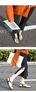 Détail de sandales bohèmes plates avec fleurs en strass et bride arrière élastique