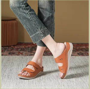 Vista de detalle de sandalias de cuña marrón naranja con correas de velcro y diseño