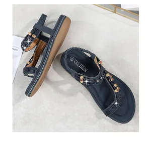 Dettaglio di un sandalo basso bohémien blu con strass vintage e accenti di perline in legno