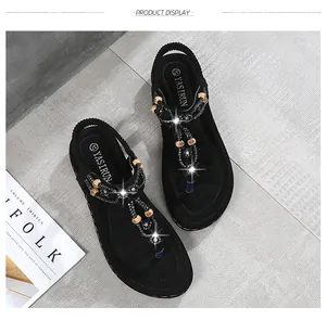 Top view of black bohemian flat sandals with sparkling rhinestones and wooden beads