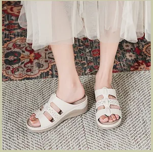 Detailopname van beige plateausandalen met elegante uitgesneden bloemmotieven en details