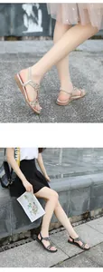 Detailed view of women's flat sandals with rhinestone flower charms and T-strap