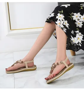 Detail of bohemian T-strap sandals with woven beads and rhinestones on apricot straps