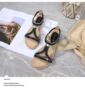Dettaglio di sandali boho con strass argentati brillanti e cinturino elastico sul tallone