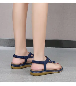 Détail de sandales tressées bleu foncé avec semelle antidérapante et talon élastique