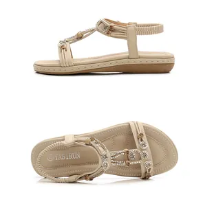 Close-up of beige T-strap sandals with intricate colorful beads and sparkly rhinestones