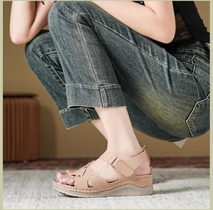 Nahaufnahme von Damen-Plateausandalen in Beige mit Kreuzriemen und Klettverschluss am Fuß